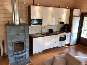 索特的住宿－Holiday Home Tokka at Iso-Syöte，厨房配有白色橱柜和壁炉