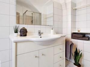 Baño blanco con lavabo y espejo en Ferienwohnung Himmelberg 80m2 in der Altstadt und toll für Familien, en Klagenfurt