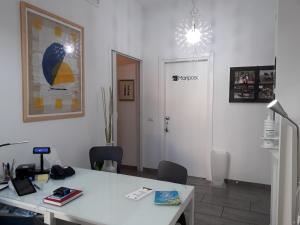 ラ・スペツィアにあるアフィッタカメレ ル ファルファッレの白いデスク、テーブル、椅子が備わるオフィス
