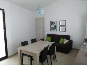 a living room with a table and a couch at Appartamento Monte Granatico 02 in SantʼAntìoco