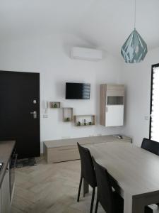 cocina y comedor con mesa y sillas en Appartamento Monte Granatico 02, en SantʼAntìoco