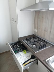 a kitchen with a stove and a counter top at Appartamento Monte Granatico 02 in SantʼAntìoco