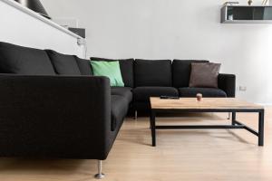 a living room with a black couch and a coffee table at Duomo Flat in Trento