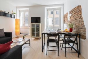 uma sala de estar com uma mesa com cadeiras e um sofá em Duomo Flat em Trento