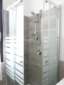 La salle de bains est pourvue d'une douche avec une porte en verre. dans l'établissement Appartamento Monte Granatico 02, à SantʼAntìoco