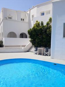 a view of a swimming pool in front of a house at Three Harites in Perissa