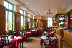 ein Restaurant mit Tischen, Stühlen und roten Servietten in der Unterkunft Etzhorner Krug in Oldenburg
