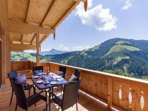 a wooden deck with a table and chairs on a balcony at Bergappartements Reithammer - Ellmau in Ellmau