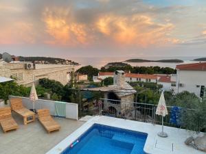 a villa with a swimming pool on top of a building at Fio's in Hvar
