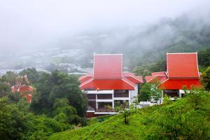 dois edifícios com telhados vermelhos no topo de uma colina em Panviman Chiang Mai Spa Resort em Mae Rim