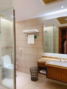 y baño con lavabo, aseo y espejo. en Luhuitou State Guesthouse & Resort en Sanya