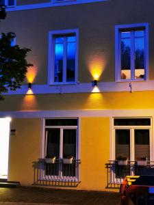 ein gelbes Haus mit Lichtern auf den Balkonen in der Nacht in der Unterkunft Rheinufer am Hindenburgpark in Bingen am Rhein