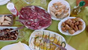 Agriturismo S'Armidda في Seùlo: طاولة مع أطباق من الطعام على طاولة
