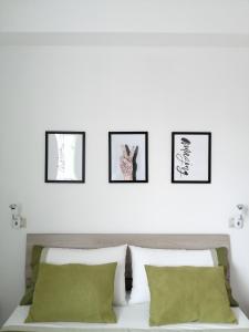a bedroom with four framed pictures above a bed at Appartamento Monte Granatico 02 in SantʼAntìoco
