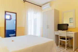 a bedroom with a bed and a desk and a television at Hotel Riviera in Trani