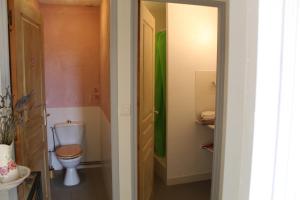 uma casa de banho com um WC e uma toalha verde em COMME UN COQ EN PÂTE em Bourg-le-Comte