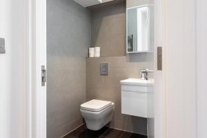 a bathroom with a white toilet and a sink at Hyde Park Apartment (SS1) in London