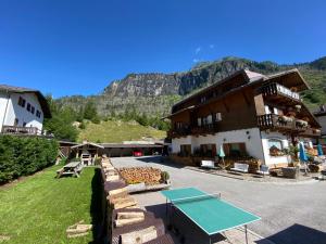 a building with a ping pong table in front of it at Hotel Camoscio in Rocca Pietore