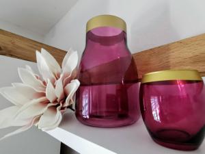 a purple vase and a flower on a shelf at Ferienhaus Rosmarie am Elbradweg in Grödel