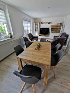 Grödel的住宿－Ferienhaus Rosmarie am Elbradweg，一间带木桌和椅子的用餐室
