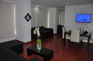 a living room with a black couch and a table at Apartamentos Plaza Modelia in Bogotá