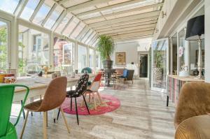 a room with windows and a table and chairs at La Maison Hôtel Mulhouse Centre in Mulhouse