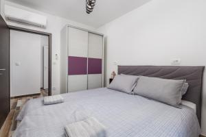 ein Schlafzimmer mit einem großen Bett mit einem grauen Kopfteil in der Unterkunft Villa Zita Lovran in Opric