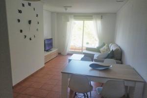 een woonkamer met een bank en een tafel bij MET&GOLF OLIVA NOVA BEACH in Oliva