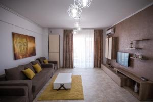 uma sala de estar com um sofá e uma televisão em Moonlight Apartments em Mamaia