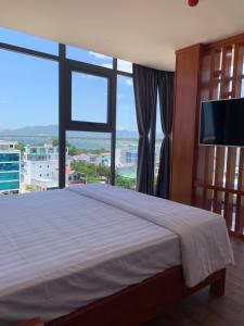 a bedroom with a large bed with a large window at HOANG SA BAI DAI Hotel in Cam Ranh