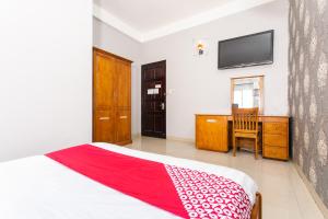 een slaapkamer met een bed, een bureau en een televisie bij Honey Hotel Da Nang in Da Nang