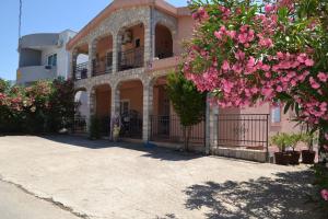 una casa con flores rosas delante de ella en Apartments Milosevic, en Bar