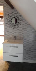 baño con lavabo y espejo en la pared en LE CHALET SUISSE - Chambre papillons en Le Vicel