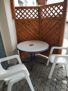 a table and two white chairs on a patio at Monteur - Ferienwohnung - Marburg-Biedenkopf - Steffenberg - mit Balkon in Obereisenhausen