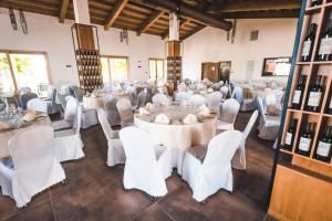 um salão de banquetes com mesas e cadeiras brancas em Agriturismo Le Anfore em Sarteano