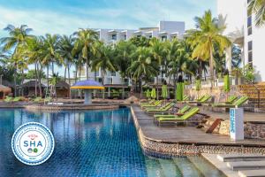 a pool at a resort with chairs and palm trees at Hard Rock Hotel Pattaya in Pattaya