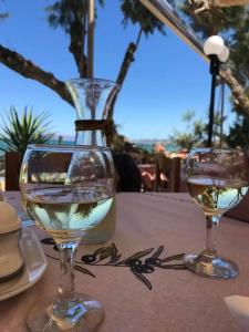 dos copas de vino sentadas sobre una mesa en Kato Stalos Mare, en Stalós