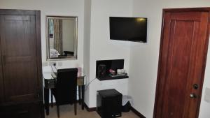 a room with a table and a television on a wall at Bay Lodge in Birchington