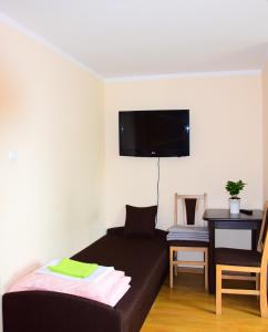 sypialnia z łóżkiem i telewizorem na ścianie w obiekcie Zajazd Nadmorski w Stegnie