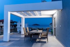 a table and chairs on a balcony with the ocean at Yiasemi Apartments in Iraklitsa