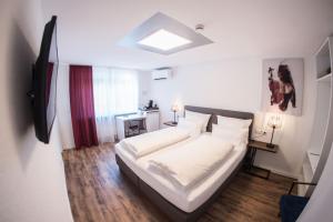 1 dormitorio con 1 cama grande con sábanas blancas en CityApartments Residence klimatisiert, en Friedrichshafen