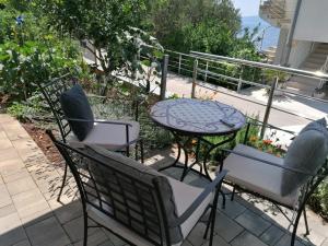 d'une terrasse avec une table, des chaises, une table et des chaises. dans l'établissement Apartmani Marinović, à Podgora