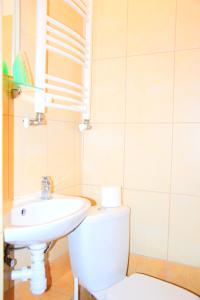 biała łazienka z umywalką i toaletą w obiekcie Zajazd Nadmorski w Stegnie