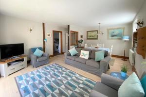 a living room with a couch and a tv at Delf Stream, close to town with lovely sunny terrace in Sandwich