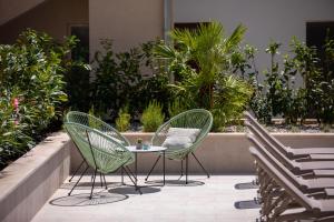 trzy krzesła i stół na patio w obiekcie Fontevita Apartments w Baskiej Vodzie