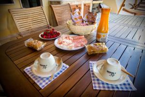 アルゲーロにあるCasa vacanze Paoliの木製テーブル(茶碗、食べ物付)