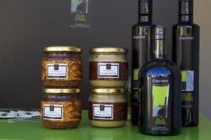 three jars of jam next to a bottle of wine at La Pintura in Trevi