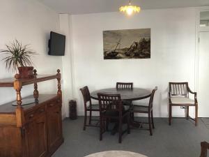 una sala da pranzo con tavolo, sedie e un dipinto di Beach Road a Margate