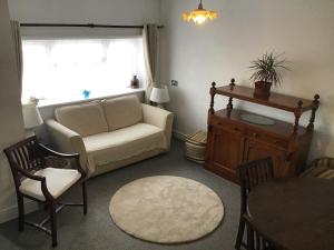 a living room with a couch and chairs and a table at Beach Road in Margate