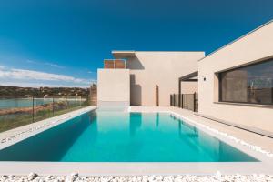 a swimming pool in the backyard of a house at Hotel le Jardin d'Emile in Porticcio